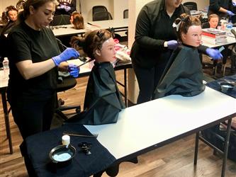 Cosmetology students learning about virgin relaxer services