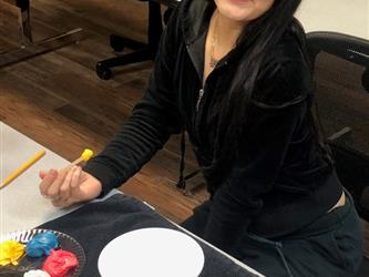 Cosmetology student smiling as she learns about color theory