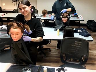 Two cosmetology students learning about virgin relaxer services