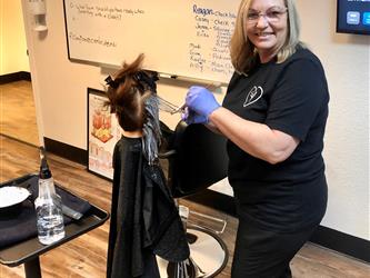 Cosmetology instructor teaching students about virgin relaxer services