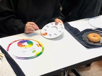 Cosmetology students smiling as they learn about color theory