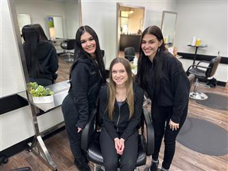 Three cosmetology students posing for a photo at Sutter County Cosmetology School