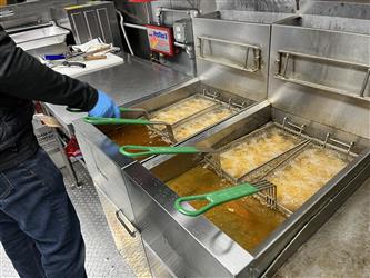 Students cooking orange chicken and rice in the food trailer