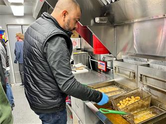 Culinary instructor cooking in the culinary trailer
